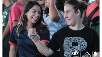 Dos jóvenes muy sonrientes bailando tomadas de las manos