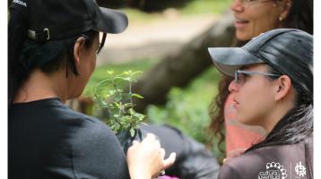 Jóvenes con una planta en la mano en una clase de jardinería