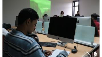 Personas en una sala frente a computadoras.