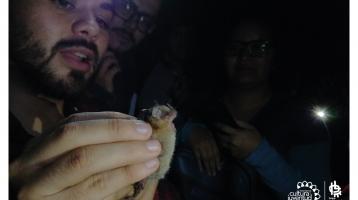 Experto mostrando a asistentes un murciélago