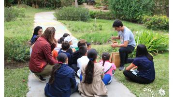 Un instructor explicando a varios niños sobre la alimentación y reproducción de especies