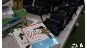 Mesa con binoculares y libros sobre aves