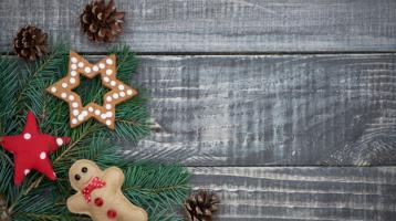 Esquina superior derecha de un árbol de navidad adornadoc on una esfera, una estrella y un muñequito