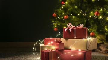 Vista frontal de un árbol de Navidad decorado y rodeado de regalos