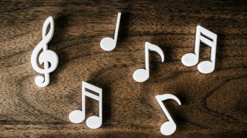 Notas musicales en blanco sobre una mesa de madera