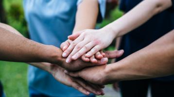 Equipo de trabajo, con las manos juntas