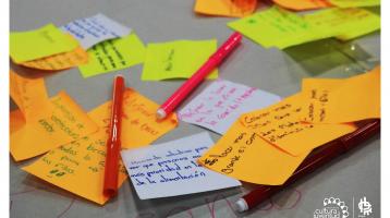 Muchos papeles de colores y lapiceros con apuntes