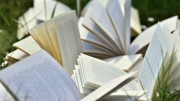 Libros abiertos en una zona verde. 