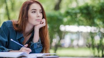 Mujer escribiendo en un parque. 