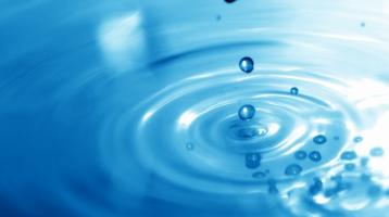 Gotas de agua cayendo sobre superficie. 