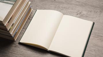 Libro abierto por la mitad sobre una mesa de madera. 