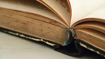 Fotografía de un acercamiento de la parte inferior de un libro abierto.