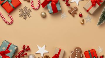 Fondo amarillo. Elementos navideños como regalos, ornamentos, galletas de navidad y melcochas.