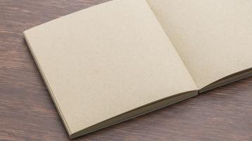 Sobre mesa de madera. Un libro abierto tipo cartón. 