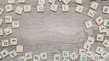 Sobre mesa de madera, diversas letras del abecedario.