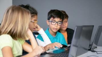 Grupo de niños utilizando una computadora.