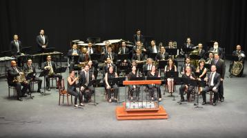 Foto de los integrantes de la Banda vestidos muy elegantes en el escenario del Teatro Melico