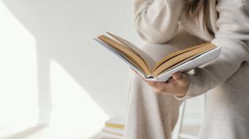 Mujer sosteniendo un libro. 