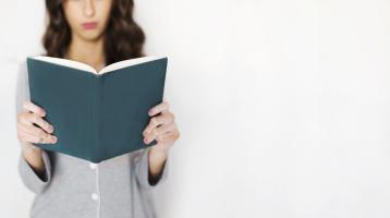 Mujer sosteniendo un libro. 