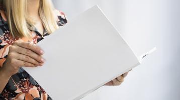 Mujer sosteniendo un libro abierto. 