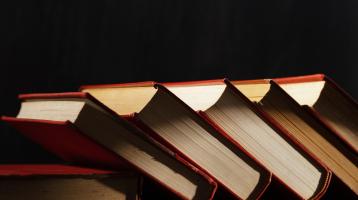 Fondo negro. Libros inclinados a media luz.