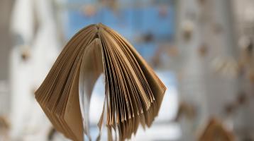Un libro colgando de fondo desenfocados otros libros colgando
