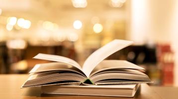 El fondo desenfocado, unos libros cerrados y otro abierto