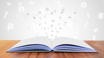 Un libro abierto con letras saliendo del libro