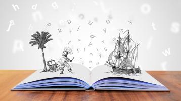 Un libro abierto con figuras dibujadas y letras dispersas
