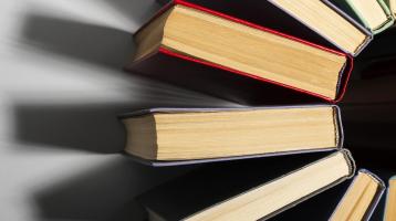 Varios libros acomodados en un semicírculo vistos desde arriba